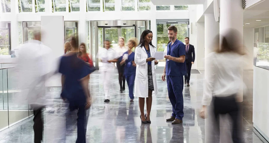 A doctor and a nurse discuss background checks on employees