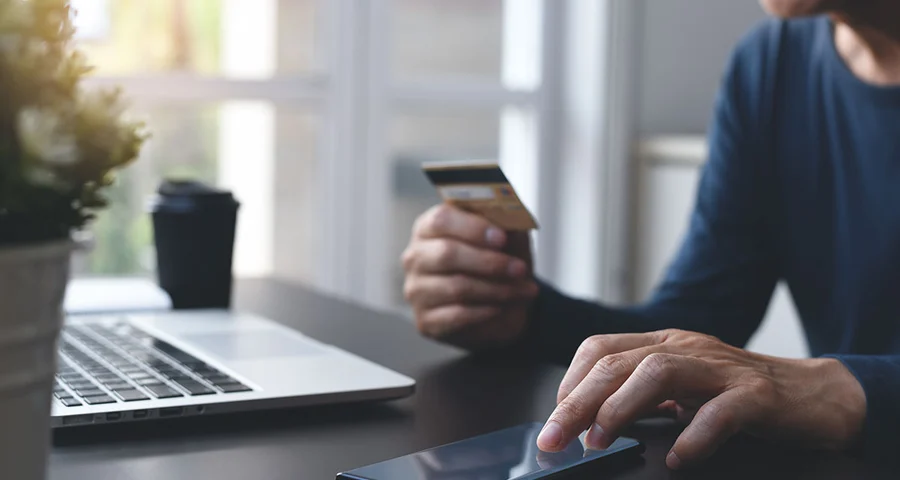 Working man laptop coffee checking credit card