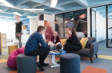 En grupp av medarbetare sitter och diskuterar