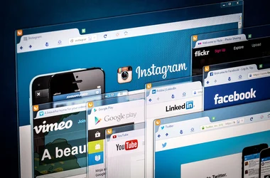 various social media homepages on a monitor screen.