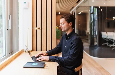 En man sitter framför en dator och arbetar med bakgrundskontroller av anställda.