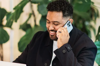 Anställd pratar i telefon och arbetar emd bakgrundskontroller