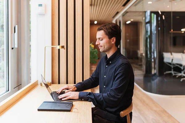 A man sitting in front of a computer reading about pre-employment screening checks