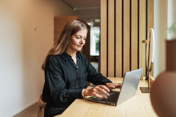 Kvinna sitter vid en dator och läser ett utdrag ur belastningsregistret