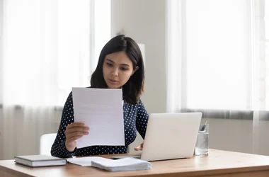 Young woman sitting at a desk and reading a document