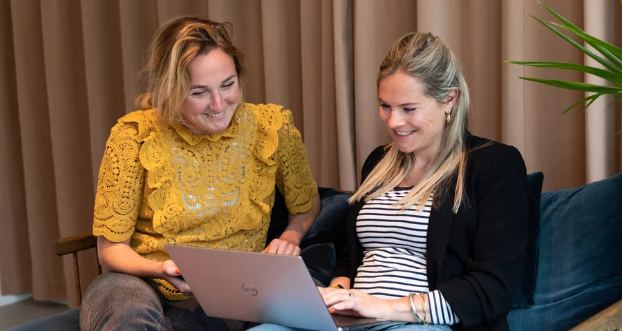 Two colleagues support the screening process on laptop