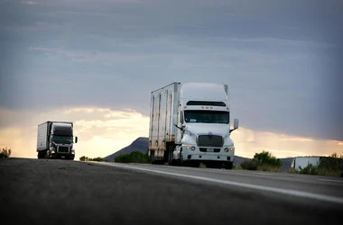 Two long-haul trucks driving on the highway