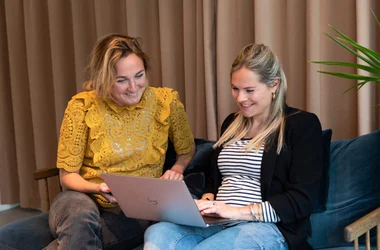 Twee collega's ondersteunen bij het screeningsproces op de laptop