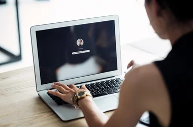 The foundation for background checks for national and international companies. Woman sitting in front of a computer writing her password.