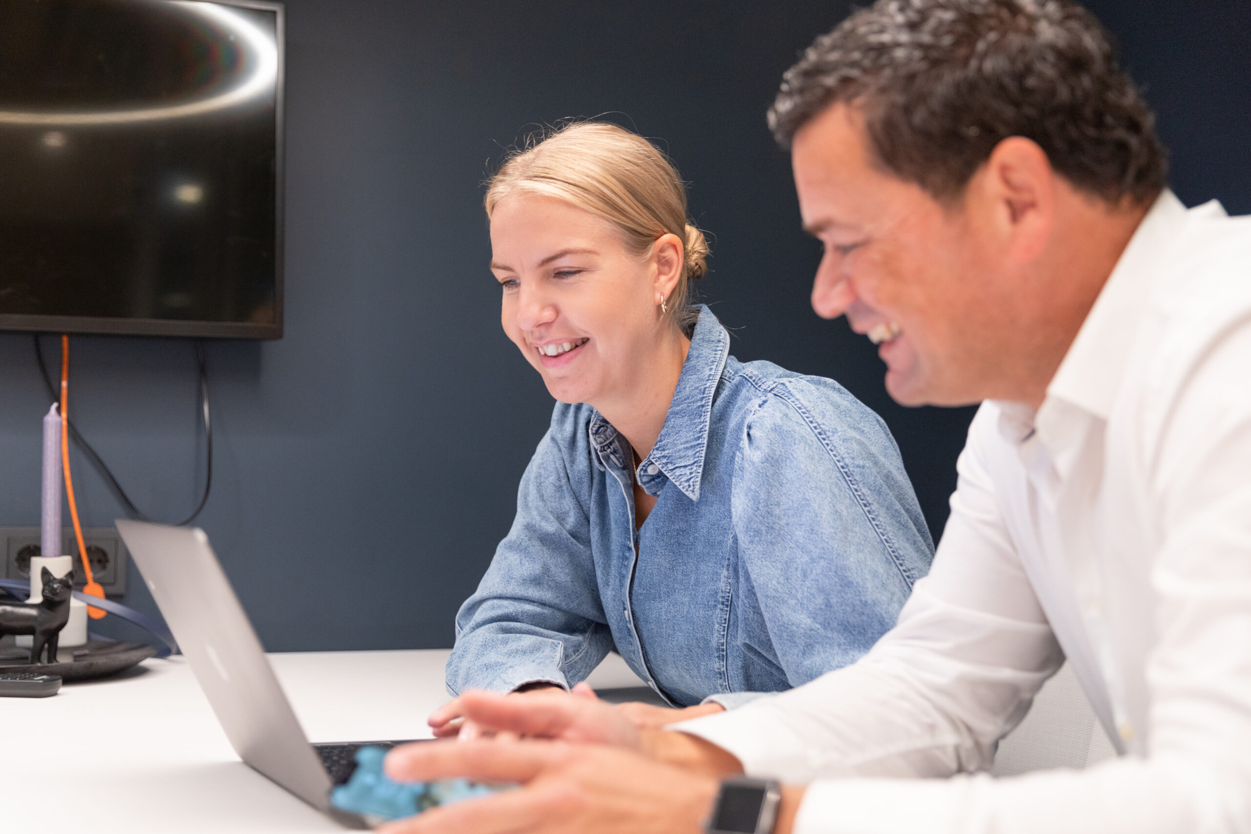 two happy coworkers looking at laptop