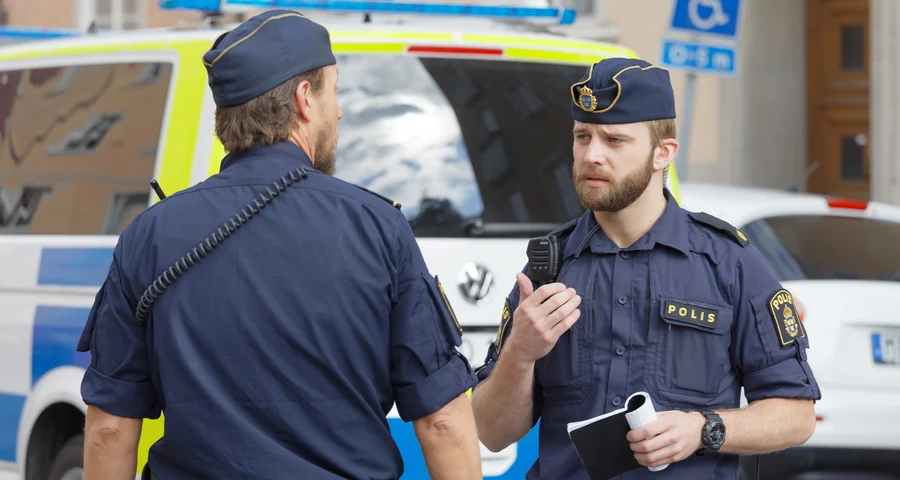 Två poliser som pratar med varandra på gatan