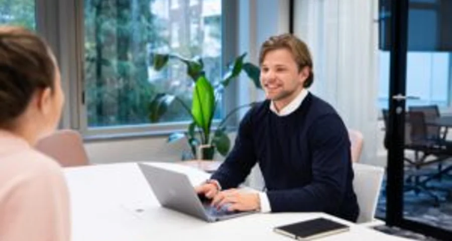 DISA worker sitting at a table using a laptop to research work experience of a job applicant